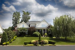 A view from the street of a large brick home with beautiful landscaping